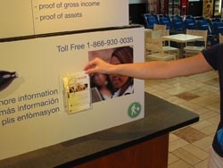 A hand grabs a Coordinated Care brochure from a display