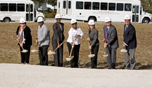 Healey Center groundbreaking group wearing hard hats and holding shovels with dirt