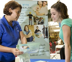 Health Care District employee explains the Vita Health program to an interested woman