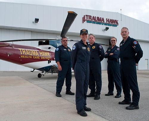 Flight crew standing in front of a Trauma Hawk helicopter