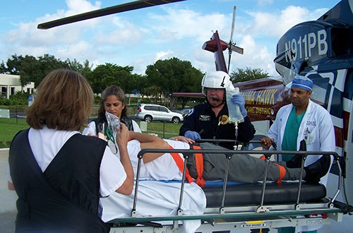 A patient on a gurney unloaded from the Trauma Hawk receiving medical care