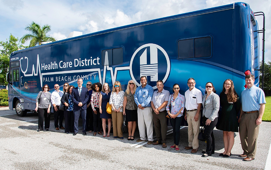 H C D Staff standing in front of new mobile medical unit