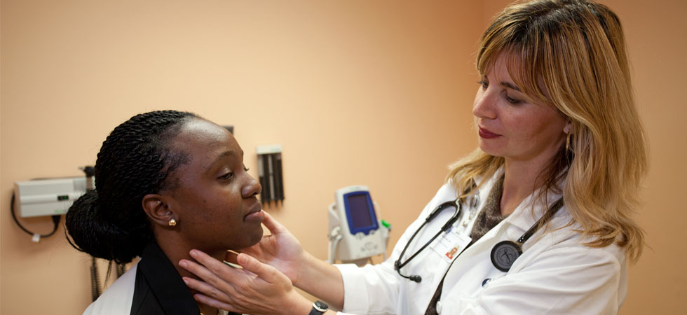 A Brumback Clinic doctor feels the neck of a patient