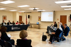 A projector displays a presentation on a pull down screen during a Lakeside Medical Center meeting