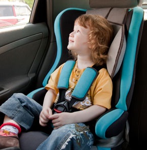 A child sitting in a safety seat in a car