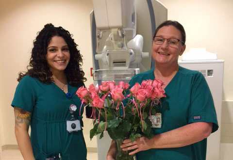 Melissa and Michelle. Michelle is holding a bouquet of pink flowers.