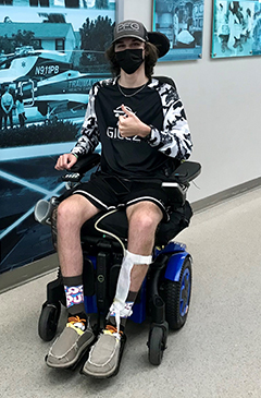 John Krolikowski wearing a mask while on a wheelchair