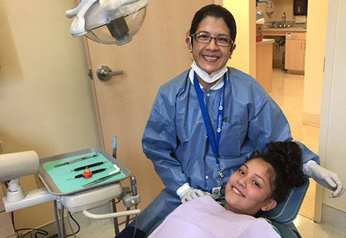 Dr. Seminario next to 13 yr old patient Sandy Perez sitting in the dentist chair
