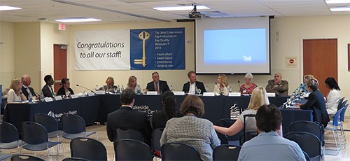 Audience in chairs and board members sitting at the table