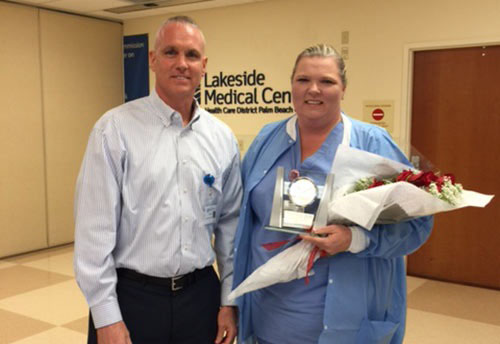 Rick Roche and Pam Ellison. Pam is holding a commemorative clock and flowers