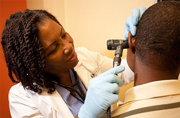 A doctor performs an ear exam on a patient at the Brumback Clinic