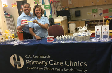 Millie and Gladys pose for a picture behind the Brumback Clinics table at the Dental Fair Expo.