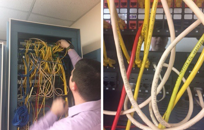 Anthony looking through tangled wires in a rack of switches