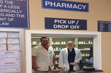 Nicholas Netzer and Jennifer Dively stand at the pharmacy pick up and drop off window