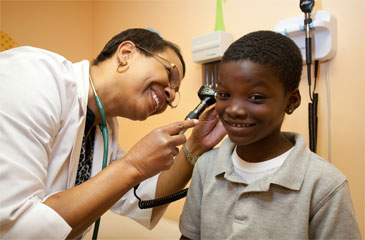 Doctor performs an ear examination on a child.