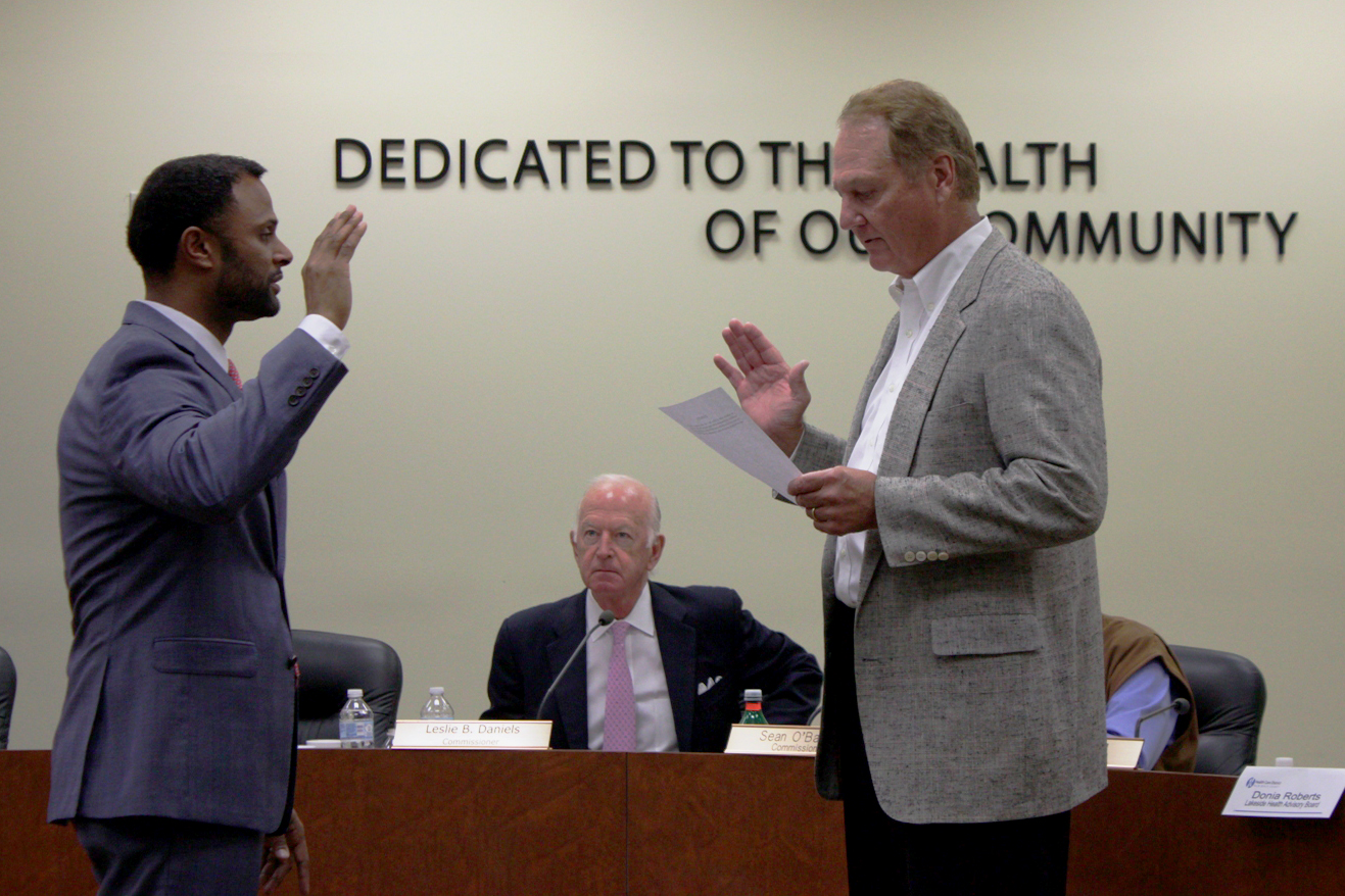 Neering being sworn in in the Health Care District board room