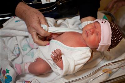 A newly born baby being kept warm in the hospital nursery.