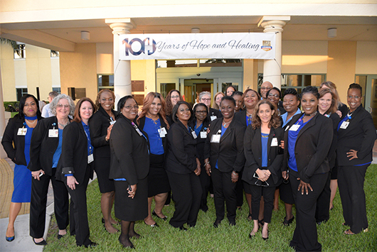 The staff stands out front of the Healey Center under a 100 years of hope and healing banner.