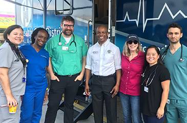 District staff in front of the mobile health clinic