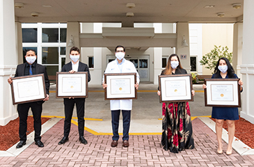 5 graduates in front of the hospital