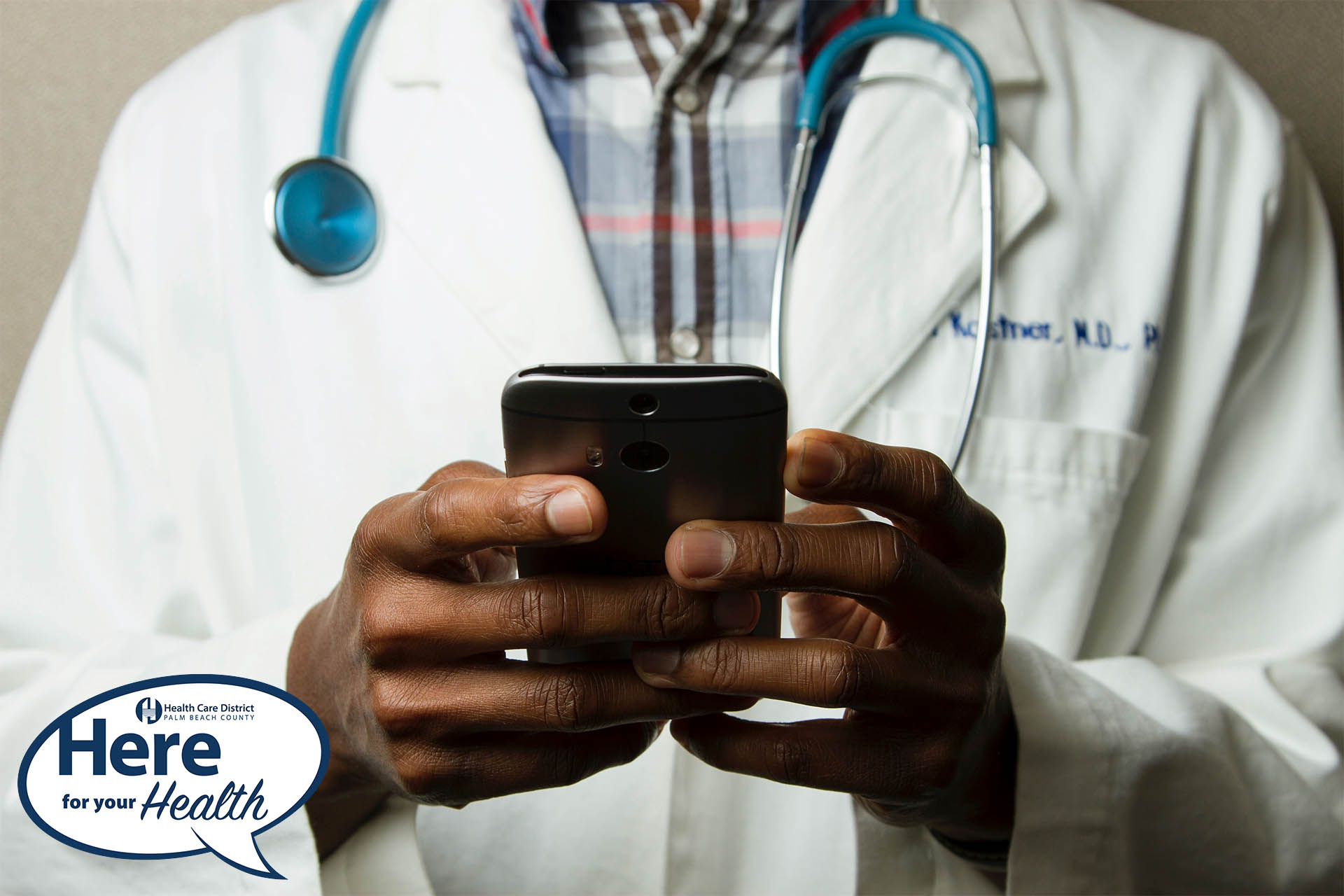A doctor types on his cell phone