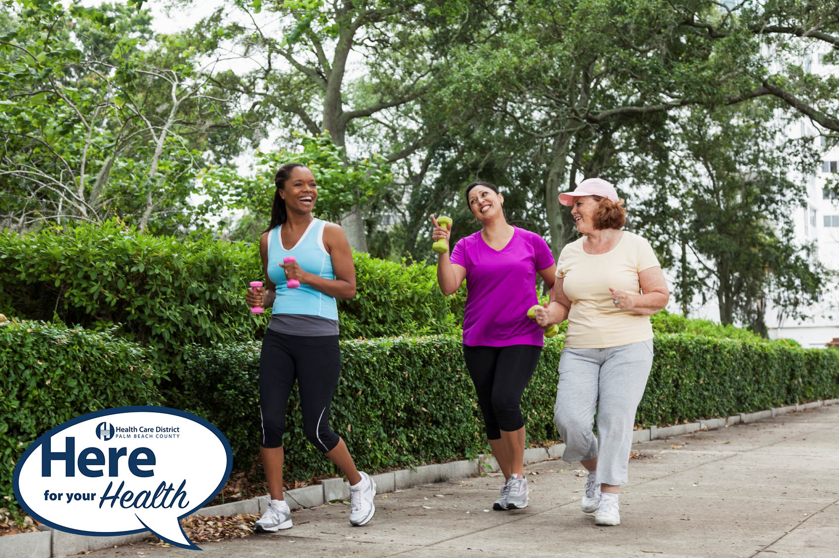 Three women having a happy conversation while jogging with dumbbells