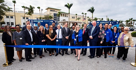 Members in front of blue ribbon on the 02-08-23 ground ambulance cutting ribbon ceremony 