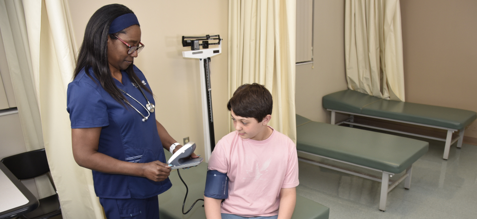 School nurse taking student blood pressure